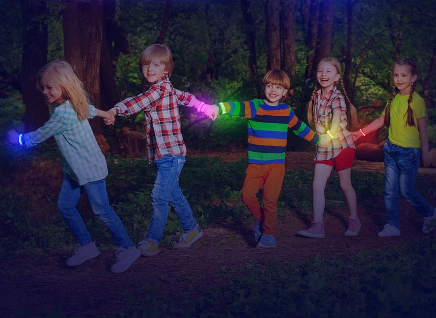 Children wearing FANL LED glow bracelets on a dark woodland path