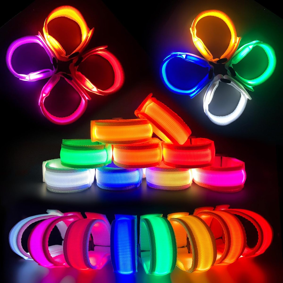 Twenty-four FANL LED bracelets glowing in eight colours on a black surface